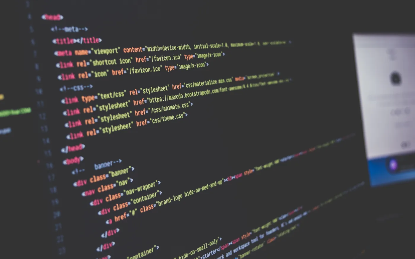 Illustrative photograph: neatly structured web page code on a screen, with the page it builds beside it