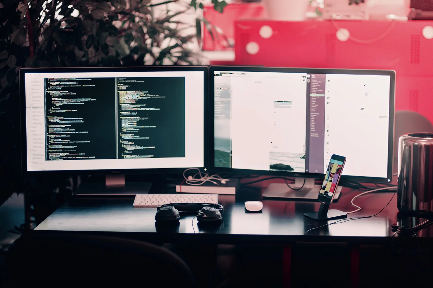 Illustrative development workstation: code on one monitor and a browser on another, with a phone on a stand for testing